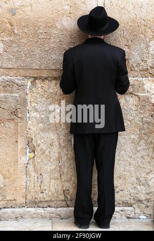 Jerusalem: Religious man prays at western wall or wailing wall in the old city Stock Photo