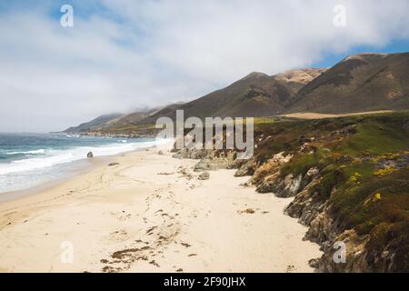 Rugged coastline of Big Sur with sandy beach and cloudy sky
