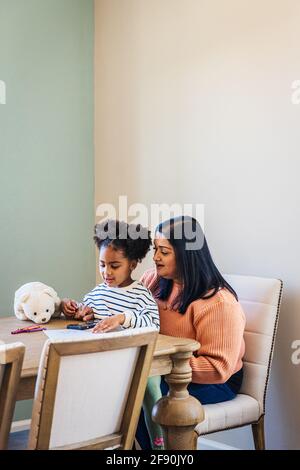 Granddaughter and grandmother using smartphone at home Stock Photo