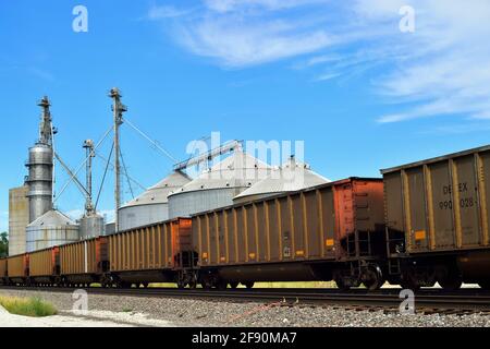 Altona, Illinois, USA. A Burlington Northern Santa Fe Railway freight train of empty coal cars passing an agriculture cooperative. Stock Photo