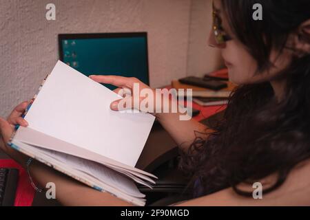 pretty middle aged latin woman reading in her work area Stock Photo