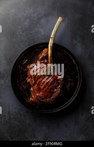 Barbecue grilled Tomahawk Steak on dark background Stock Photo