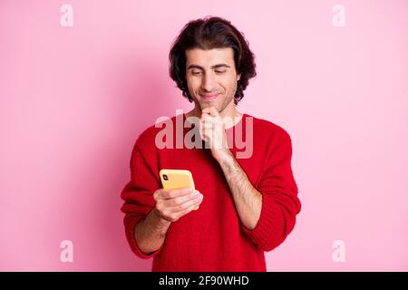 Portrait of nice focused cheery guy holding in hands using device browsing web wi-fi isolated over pink color background Stock Photo