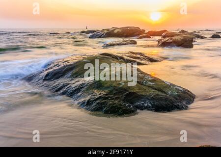 Sunrise over the rocks, Hua Hin beach, Prachuap Khiri Khan, Thailand Stock Photo