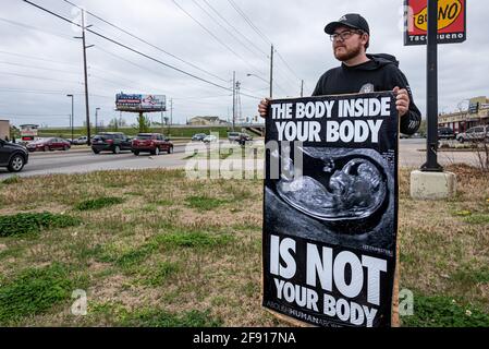 Abortion abolitionist human-rights advocate holding a poster along a busy highway near an abortion facility in Tulsa, Oklahoma, to educate and remind passers-by and to stand in the gap for defenseless pre-born human beings. (USA)