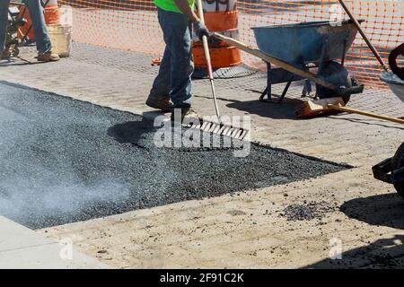 Construction site is worker laying new asphalt road Stock Photo