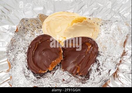 Easter Egg - Stuffed homemade chocolate egg. Isolated on aluminum foil background. Top view. Stock Photo