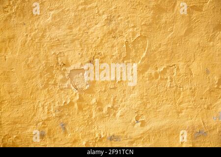 Yellow old scratched and cracked stucco wall on the facade of the back design blank Stock Photo