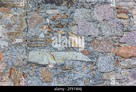 Old stone wall textured background made of different stones Stock Photo
