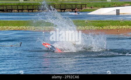 Mackay, Queensland, Australia - April 2021: Man learning to wakeboard at a cable ski park and falling off as the rope pulls Stock Photo