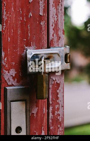 The old rusty padlock on the red door Stock Photo