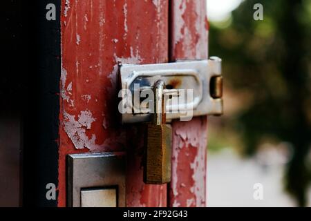 The old rusty padlock on the red door Stock Photo