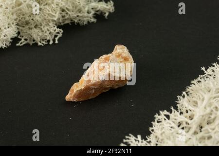 Orange Calcite from Brazil. Natural mineral stone on black background. Mineralogy, geology, magic of stones, semi-precious stones and samples of miner Stock Photo