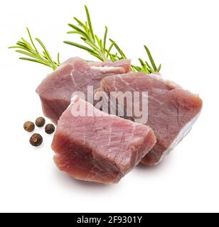 Raw, juicy and fresh chunks (dice shaped) of pork tenderloin. With rosemary leaves and black pepper. Isolated on white background. Stock Photo