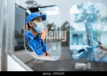 seen from the window of a male driver in a uniform and wearing a mask while behind the wheel Stock Photo