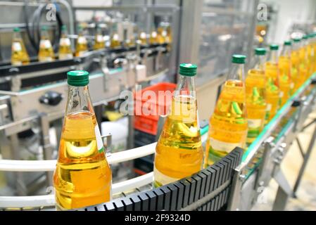 apple juice in glass bottles in a factory for the food industry - bottling and transport Stock Photo