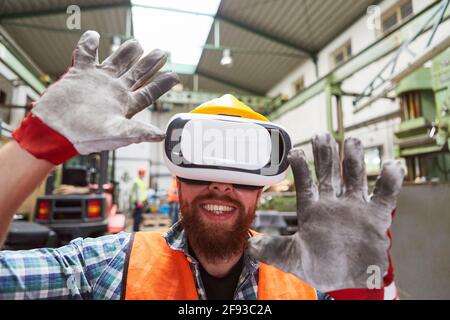 Workers with VR glasses in a factory hall while visualizing the industry of the future Stock Photo