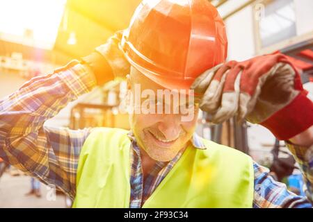 Worker with hard hat when helmets are mandatory as occupational safety in factory Stock Photo