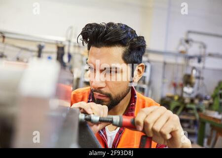 Man in locksmith or metal worker training works in metal construction workshop Stock Photo