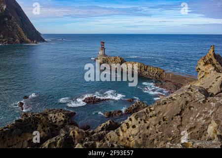 San Sebastian, Spain - March 1, 2021: Puntas Lighthouse and the rugged coastline at the mouth of the Rio Oyarzun in Pasajes Stock Photo