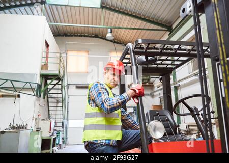 Warehouse clerk with experience as a forklift driver on the forklift in the warehouse of a freight forwarding company Stock Photo
