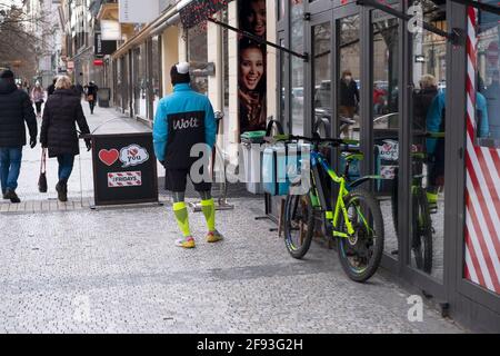 Prague, CZ - 13 January 2021: Wolt company bike driver, fast-food delivery biker Near His Bike. Illustrative editorial Stock Photo