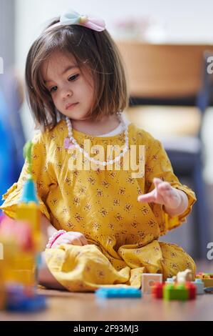 Little girl play with blocks in room. Small kids learning theme Stock Photo