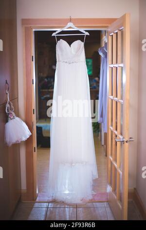 Bride's wedding dress hung up Stock Photo
