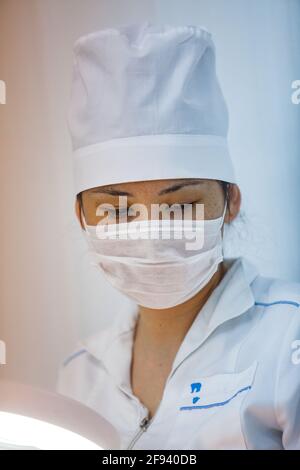 Atyrau, Kazakhstan. Medical syringe production plant.Young Asain woman operator on production line. Close-up. Stock Photo