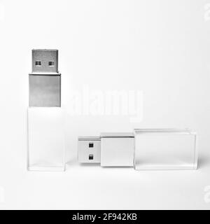 Two glass transparent USB drives with a metal insert on a grey background. Layout. Copy space. A high resolution. Stock Photo