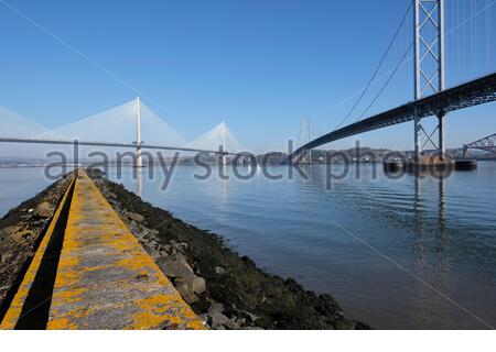 South Queensferry, Scotland, UK. 16th Apr 2021.  Cool clear and sunny at South Queensferry and Forth Estuary with a view of the Forth Bridges. With the easing of the Covid-19 Coronavirus lockdown measures and travel restrictions across Scotland from today, people start to visit and enjoy the outdoors at the usual visitor hotspots. Credit: Craig Brown/Alamy Live News Stock Photo