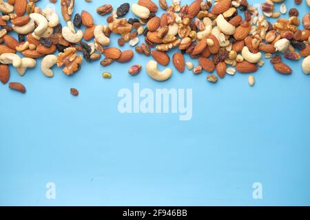close up of many mixed nuts on blue background  Stock Photo