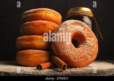 Doughnuts with powdered sugar against dark background, Studio shot Stock Photo