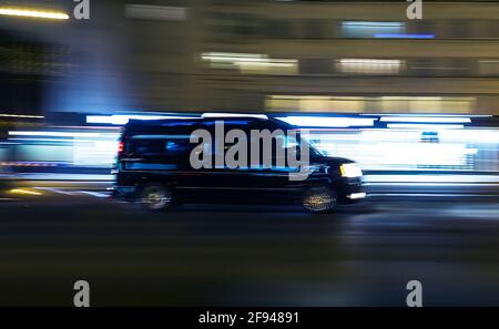 black minivan moves through the night Avenue. Blurred motion Stock Photo