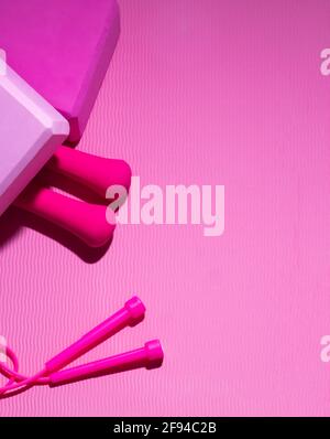 Jump rope, dumbbells, yoga blocks on the background of a ribbed Mat. Sports items. Copy space. Stock Photo