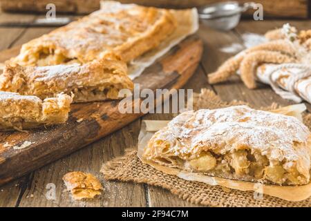 Traditional homemade apple strudel on a rustic wooden table Stock Photo
