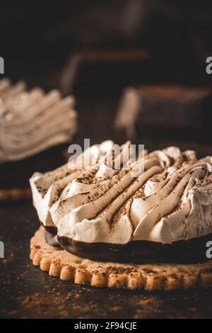 Big meringue chocolate cookie tartlet on brown background, vertical Stock Photo