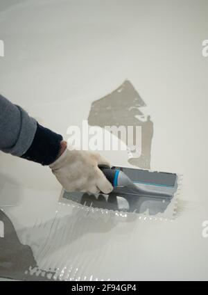 worker applies waterproofing with a small brush Stock Photo