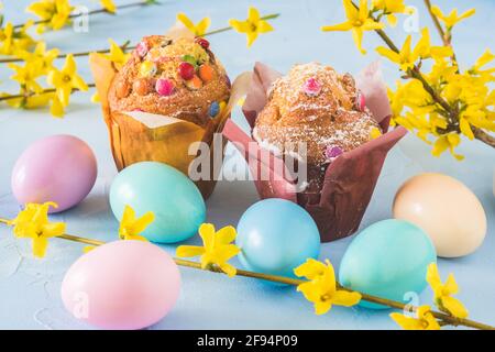 Muffins with chocolate, colorful Easter eggs and forsythia branches Stock Photo