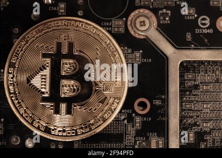 Bitcoins lie on the video card, concept of mining. Electronic virtual money for web banking and international network payment. Symbol of crypto currency. High quality photo Stock Photo