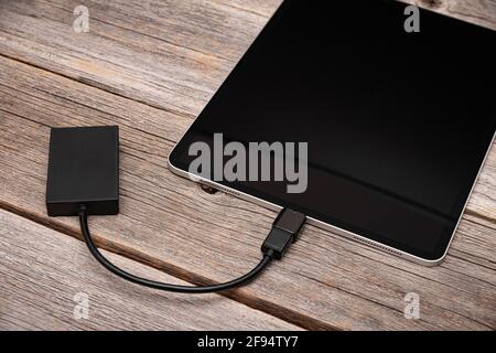 Memory card or external hard drive is connected to the Tablet PC. Stock Photo