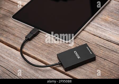 A Apple Ipad Pro with an XQD memory card connected via OTG via a card reader. Stock Photo