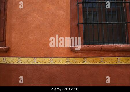 Colonial house facade with a stone trimmed window on a Venetian stucco wall in the historic center of Santiago de Querétaro, Mexico. Stock Photo