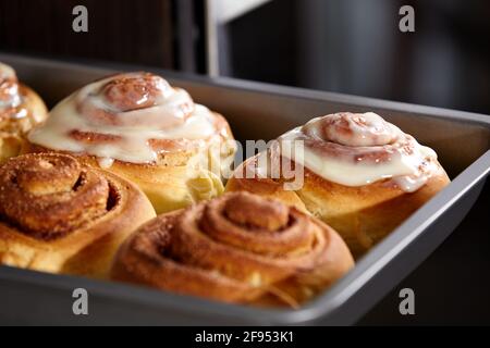 Fresh bakery. Cinnamon rolls are oiled. Homemade buns close up. Stock Photo