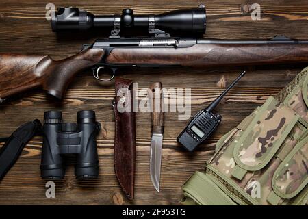Hunting rifle and ammunition on a dark wooden background.Top view., Hunting rifle and ammunition on a dark wooden background.Top view. Stock Photo