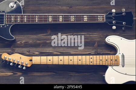Two guitars on a dark wooden board. Stock Photo