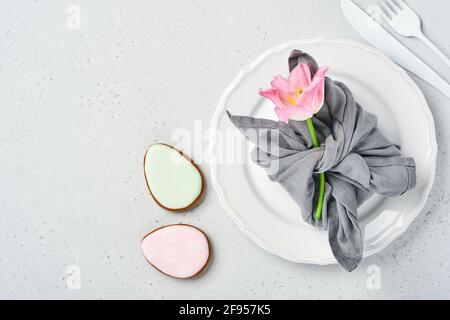 Easter table setting with floral decor on gray table. Elegance dinner. Mock up. Top view. Stock Photo