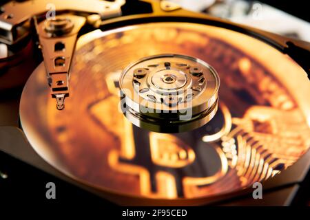 Inside of an open computer hard drive with the projected bitcoin symbol Stock Photo