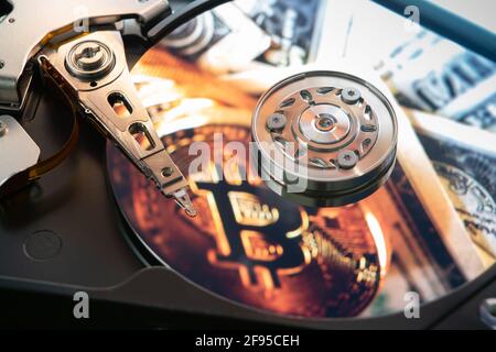 Inside of an open computer hard drive with the projected bitcoin symbol Stock Photo