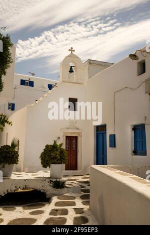 A crow-stepped gable leads to a bell tower and cross at a Greek church on the island of Mykonos.